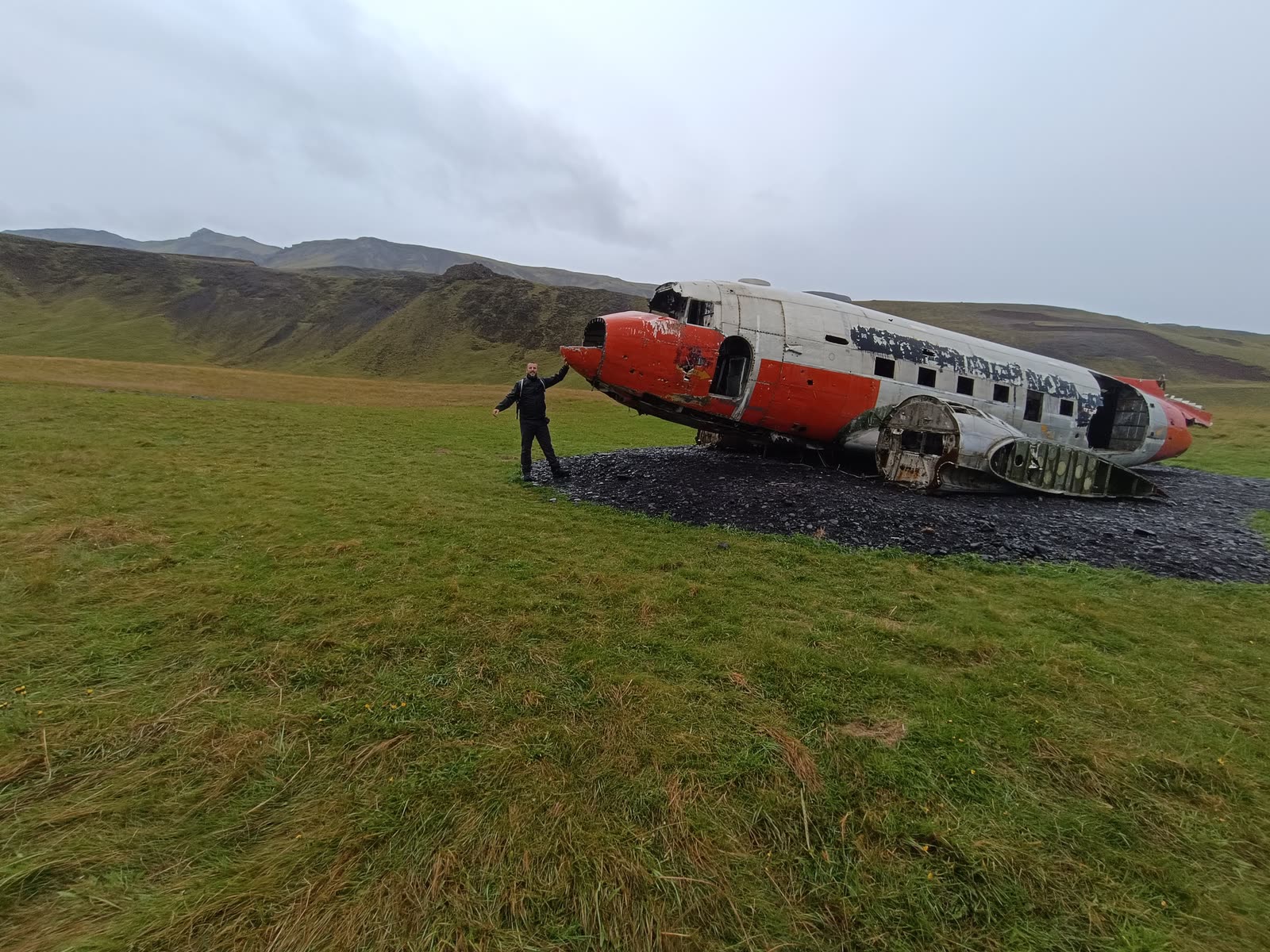 Una persona junto a los restos de un avión en una llanura de Islandia