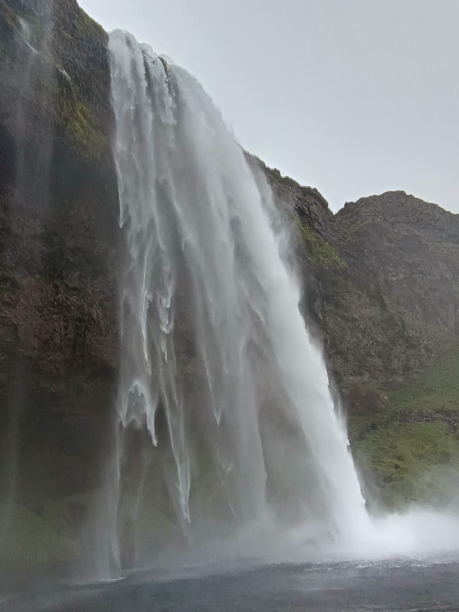 Cascada vista desde cerca, con agua y bruma descendiendo junto a la roca